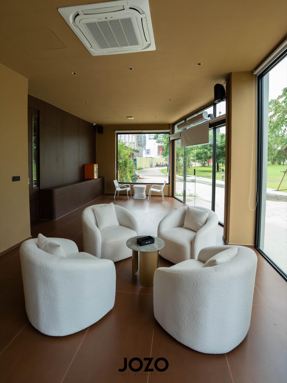 White lounge chairs beside large windows in the JOZO spa.